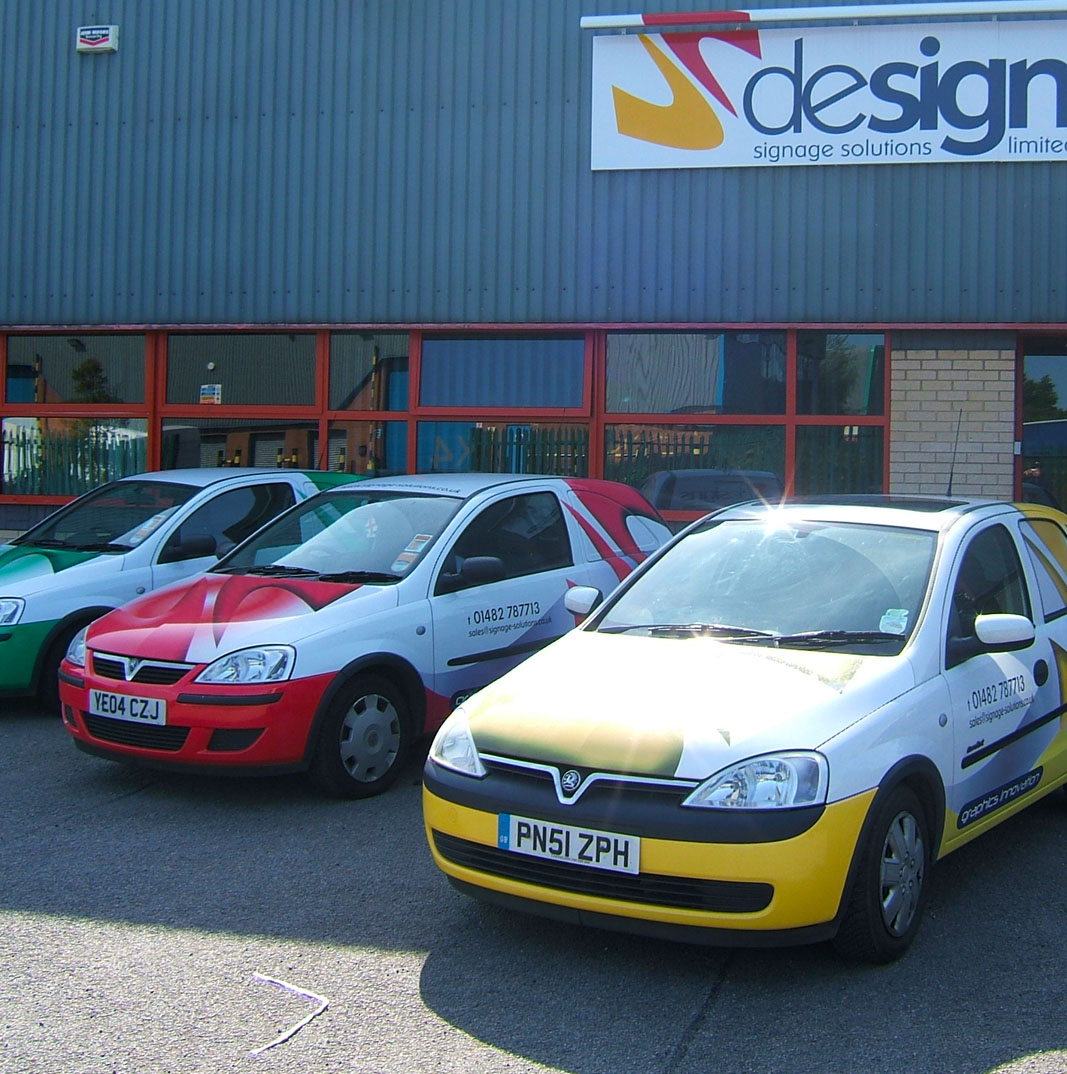 Photo of Designs company building with three cars outside.